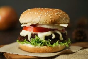 Burger on a sesame seed bun with lettuce, tomato and cheese, made with wholesale burger buns