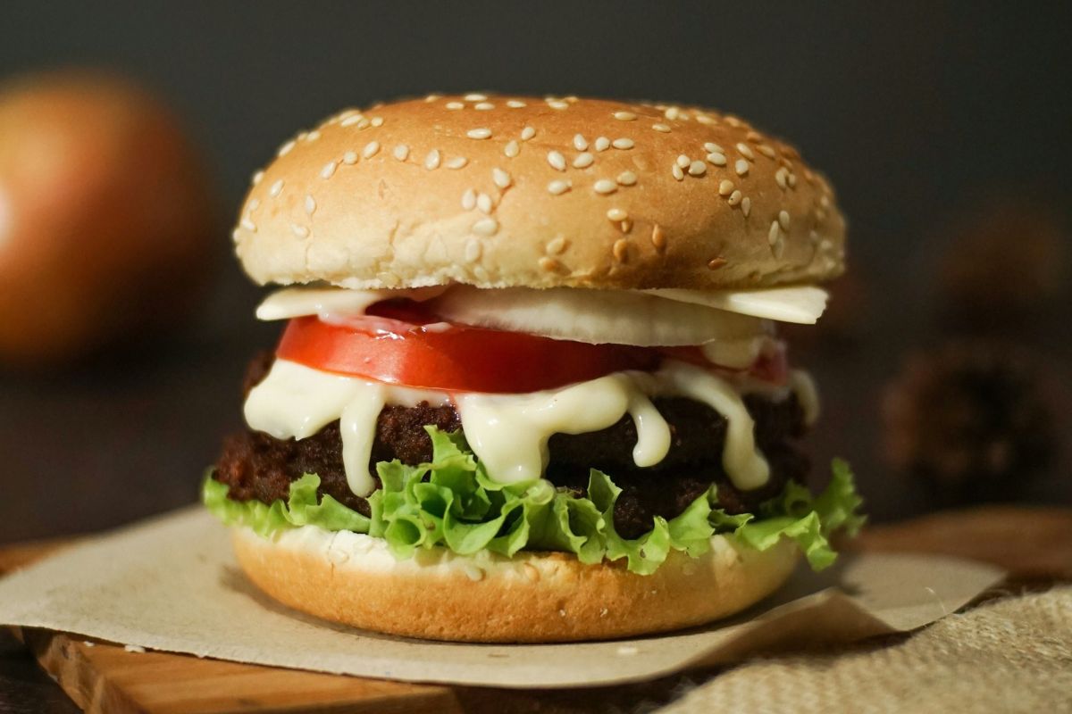 Burger on a sesame seed bun with lettuce, tomato and cheese, made with wholesale burger buns